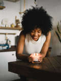 black woman holding lit candle