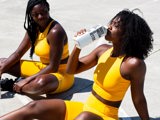 two black people in yellow gym clothes drinking water