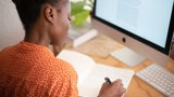 black woman making notes from computer