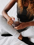 black woman on bed with coffee