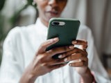 woman texting on phone with green phone case