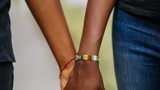 two black people holding hands with African beads