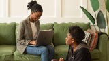 black woman with laptop on soft and black girl sitting on the floor