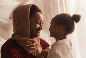 black woman in headscarf with small young girl